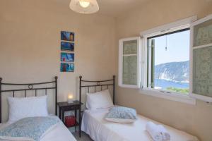 two beds in a bedroom with a window at Homer's View in Stavros