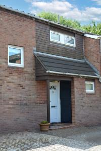 a red brick house with a white door at Large 2 bedroom house in Wombridge