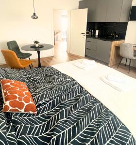 a room with a bed and a kitchen with a table at Ahat apartment- Modern stay near center & free parking in Maribor +20 photos