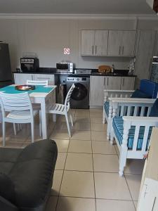 a kitchen with a table and chairs and a kitchen with a stove at J&B Tuiste in Reebok