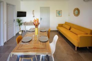 a living room with a table and a yellow couch at Casa di Sole in Sotta