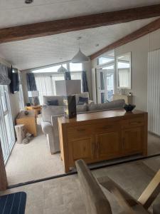 a living room with a couch and a table at Aurora luxury beach lodge in Lossiemouth