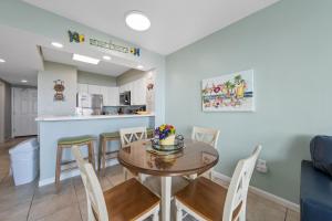 a dining room and kitchen with a table and chairs at Silver Beach 104 PET FRIENDLY! in Orange Beach +30 photos