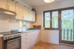 a kitchen with white cabinets and a sink and a window at Vineyard Cottage Vrbek in Roginska Gorca
