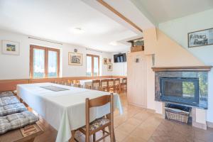 a dining room with a table and a fireplace at Vineyard Cottage Vrbek in Roginska Gorca