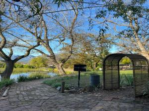 an archway in a park next to a body of water at Picardie Guest Farm in Paarl