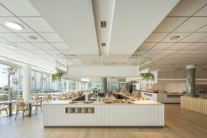a large kitchen with tables and chairs in a cafeteria at AR Diamante Beach & SPA Hotel 4 SUP in Calpe