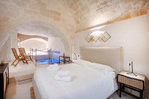a bedroom with a large white bed in a room at Stone Living - Nel cuore dei Sassi di Matera in Matera +37 photos
