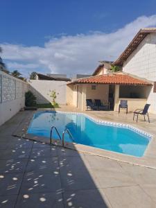 a swimming pool in front of a house at Suíte Pé na Areia do Flamengo in Salvador