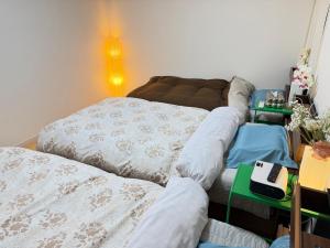 a living room with two beds and a table at 孔雀民宿 in Osaka