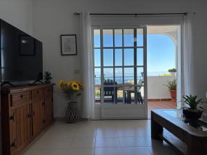 a living room with a sliding glass door to a patio at Panoramic View Balcón del Atlántico in Adeje