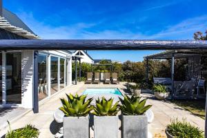 a patio with a pool and some potted plants at The Bay Cottage in Pringle Bay