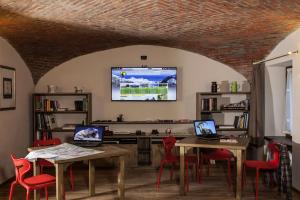 Pokój z dwoma stołami i krzesłami z laptopami w obiekcie La Pietra Felice w mieście Introd