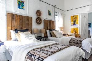 two beds in a room with white walls at The Bay Cottage in Pringle Bay +28 photos