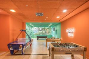 two foosball tables in a room with orange walls at AR Diamante Beach & SPA Hotel 4 SUP in Calpe