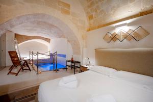a bedroom with a bed and a chair in a room at Stone Living - Nel cuore dei Sassi di Matera in Matera