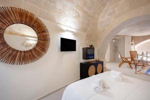 a room with a large mirror and a tv at Stone Living - Nel cuore dei Sassi di Matera in Matera