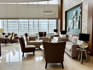 a living room with couches and chairs in a building at 2 Bedroom Condo SMDC Breeze Residences in Manila