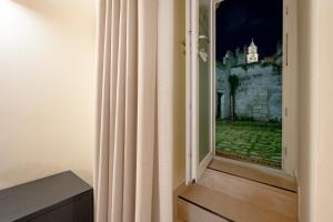 a room with a window with a view of a castle at Stone Living - Nel cuore dei Sassi di Matera in Matera