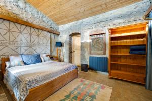 a bedroom with a bed and a stone wall at Lost Ridge Inn, Brewery & Ranch in Sighnaghi +199 photos