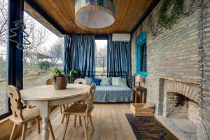 a room with a table and a bed and a brick wall at Lost Ridge Inn, Brewery & Ranch in Sighnaghi