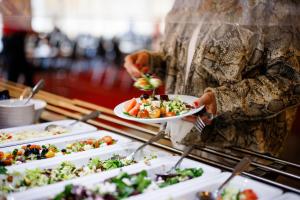 a woman holding plates of food on a buffet at Quality Hotel Bodensia in Boden