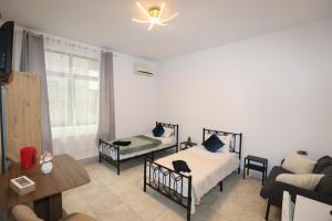 a living room with two beds and a couch at MLR Residence - Free Private Parking in Timişoara
