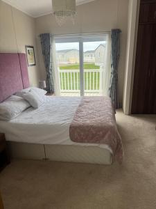a bedroom with a bed and a large window at Aurora luxury beach lodge in Lossiemouth +57 photos