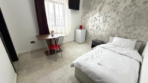 a bedroom with a bed and a table and a window at MLR Residence - Free Private Parking in Timişoara +3 photos