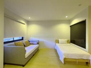 a room with two beds and a couch and a flat screen tv at Klongrien Boutique Hotel in Hat Yai +32 photos