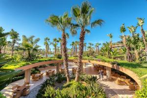 a view of the resort with palm trees and a bridge at Acacia Resort in Campofelice di Roccella