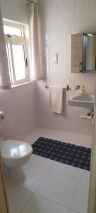 a white bathroom with a toilet and a sink at Sunlight house in Marsaskala +5 photos
