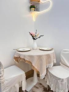 a white table with two chairs and a table with a table cloth at Sweetluxx - SMDC Green 2 Residences Staycation in Dasmariñas