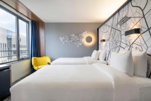 a hotel room with two beds and a window at Pestana Brussels Schuman in Brussels +29 photos