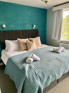 a bed with two stuffed animals on top of it at Alloa in Newby Bridge