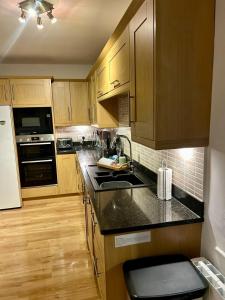 a kitchen with wooden cabinets and black counter tops at Alloa in Newby Bridge +51 photos