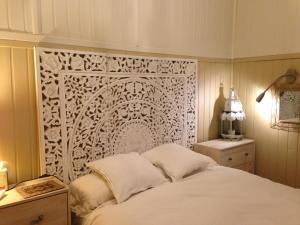 a bedroom with a bed with a white headboard at Charming villa with a private pool in Las Rozas de Madrid