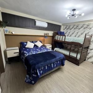 a bedroom with a bed and two bunk beds at Casa Bri in Antiguo Cuscatlán