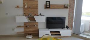 a living room with a television on a white entertainment center at Sunlight house in Marsaskala