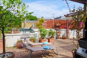 a patio with two tables and potted plants at Lisa's Stylish Top Floor Flat & Double Pool in Pietra Ligure