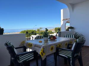 a table on a balcony with a table and chairs at Panoramic View Balcón del Atlántico in Adeje