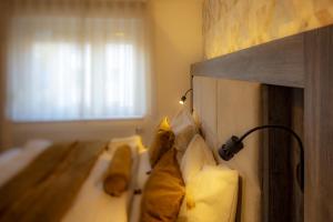 a room with three beds with a light on the wall at Hotel Zur Feldmühle in Arnsberg