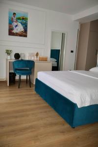 a bedroom with a bed and a desk with a chair at Mas Motel in Bosanska Gradiška