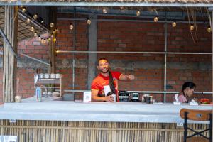 a man standing behind a counter with a woman behind it at Teko Paradise and Kitchen in Phumĭ Kruŏs