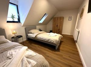 a attic bedroom with two beds and a window at ODA Living Lüneburg in Lüneburg