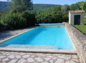 a swimming pool with a tube in the middle of a yard at Gîte de charme SPA privatif, Piscine L'oustau di Tonin in Malaucène