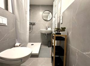 a bathroom with a white toilet and a sink at ODA Living Lüneburg in Lüneburg +2 photos
