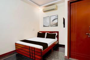 a bedroom with a bed with a white and red bed frame at SPOT ON Sj Comforts Boarding And Lodging in Jigani