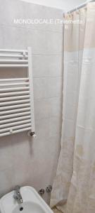 a bathroom with a white shower curtain and a toilet at Dimora Nonna Angela in Alberobello