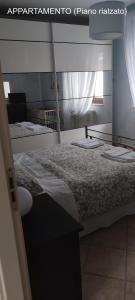 a bedroom with a mirror and a bed in it at Dimora Nonna Angela in Alberobello